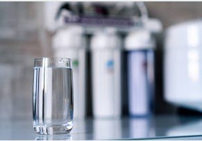 A glass of water sitting on a kitchen counter.