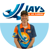 A person in a colorful uniform with a company logo smiling in front of a promotional backdrop during the "meet the team" event.