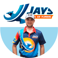 A man in a colorful uniform with a logo stating "jay's heating air plumbing" stands in front of a team logo backdrop.