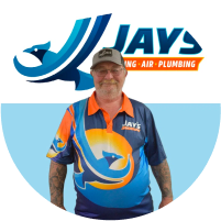 A man in a colorful uniform with the logo "jay's air plumbing" standing in front of a team logo backdrop.