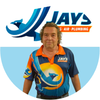Man in a branded work uniform standing in front of a company logo, ready to meet the team.